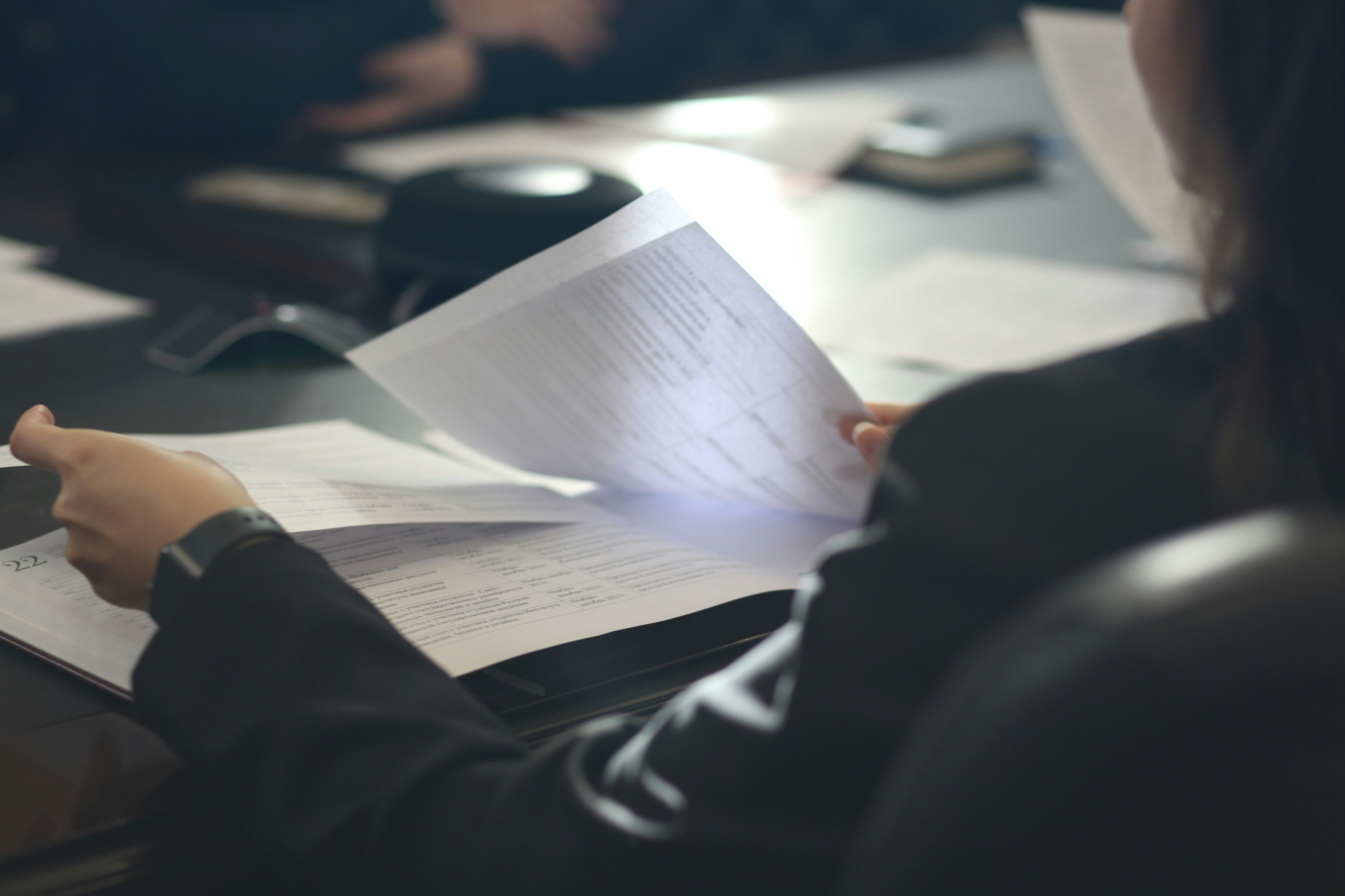 An advisor's hands reviewing a client's documents at a desk